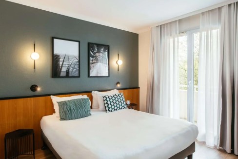 Hotel bedroom with contemporary design, cozy bedding, and scenic view.