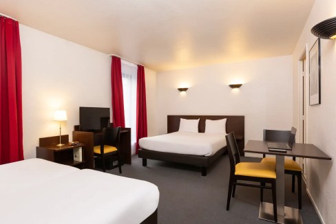 Apt hotel room with contemporary decor, comfortable beds, and workspace in La Défense, Paris.