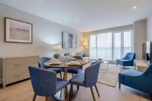 Spacious living area with dining table, sofa, and large windows in Westferry Circus apartments.