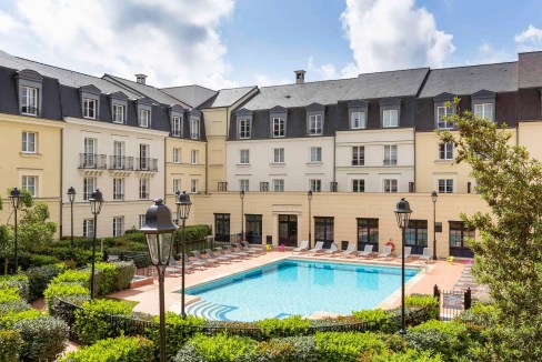 Pool area at Disneyland® Paris Lac de Serris Aparthotel with surrounding greenery.