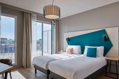 Hotel room with balcony, bright decor, and contemporary furnishings in Toulouse Saint Cyprien Aparth.