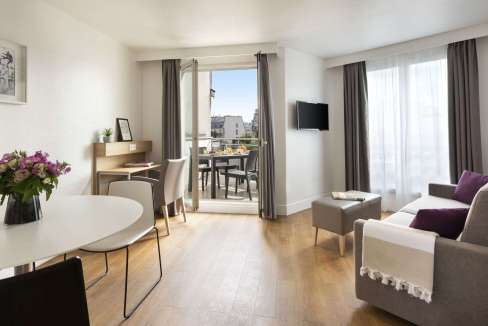 A modern, bright living room at Paris Richard Lenoir Aparthotel with stylish furniture and balcony v.