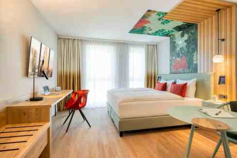Comfortable hotel room at Vienna Kagran Westfield Aparthotel featuring contemporary design and vibra.