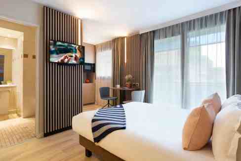 Comfortable hotel room with contemporary furnishings and large windows at Paris Esplanade de la Défe.