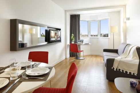 Bright living room at Gare Montparnasse Aparthotel in Paris, featuring contemporary furniture and sc.
