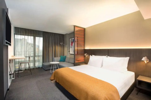 Aparthotel room in Leipzig with contemporary design, cozy bed, and modern amenities.