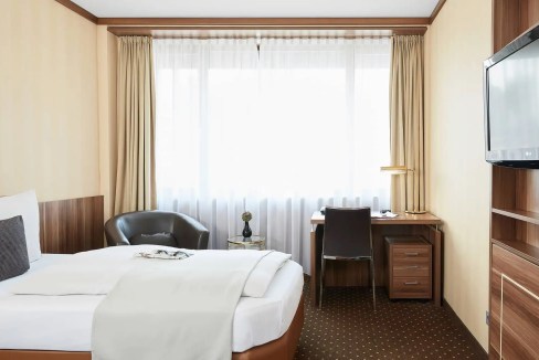 Aparthotel room in Dusseldorf near Kirchplatz, modern furnishings, comfortable bed, workspace, and n.