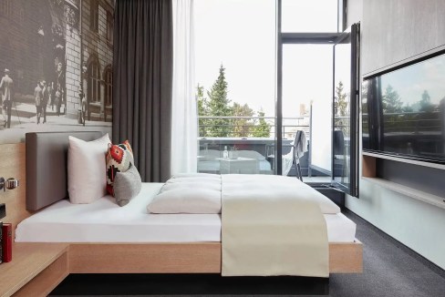 Modern hotel room with balcony and city view in Frankfurt South City.