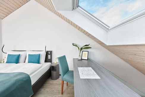 Bright hotel room with skylight and modern decor in Nuremberg.