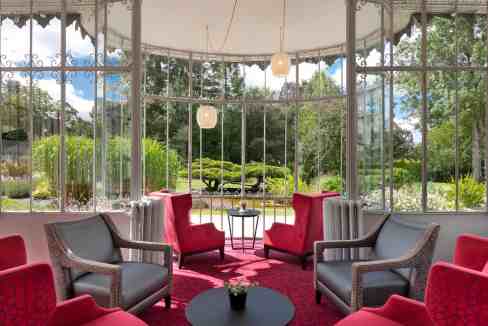Luxurious hotel lounge with comfortable seating and panoramic garden views.