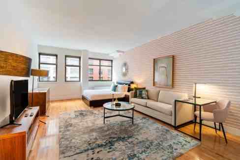 Bright living room in Lenox Hill 3rd Avenue Apartments with modern furniture and large windows.
