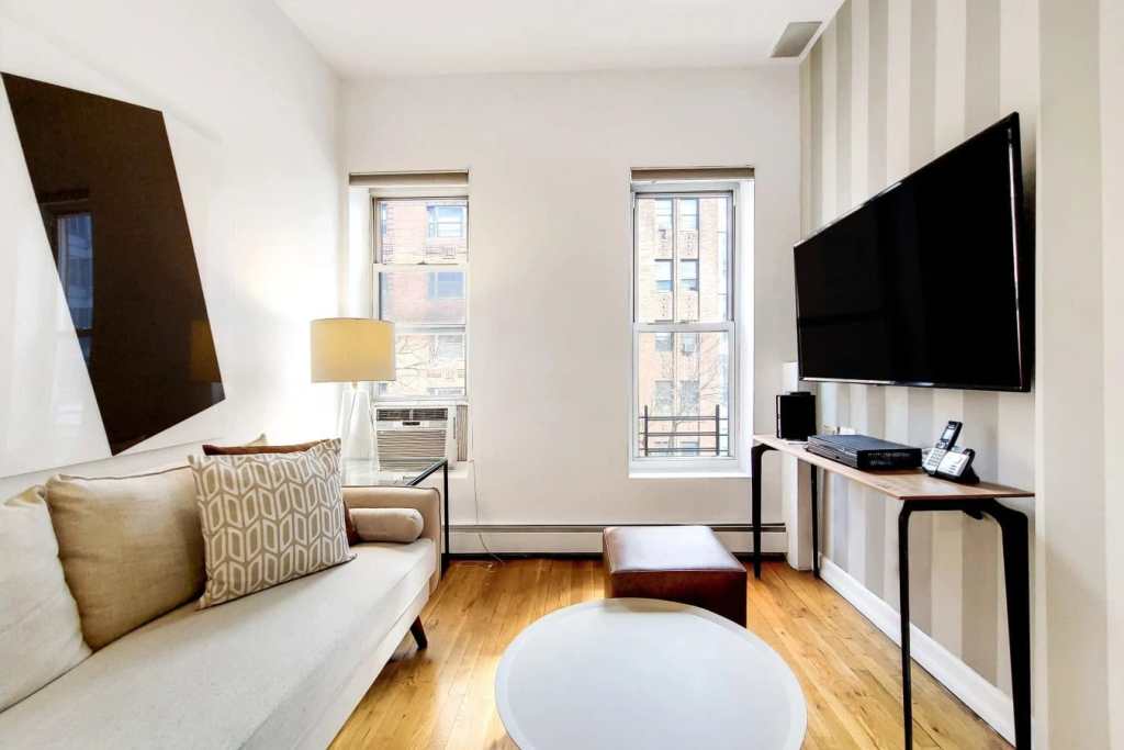 Bright living room in Lenox House Serviced Apartments with large windows and contemporary decor.