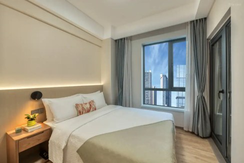 Bright hotel room with city skyline view at Changsha Xiangyue Road Aparthotel.