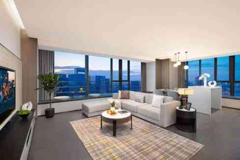 Modern living room in Chengdu Tianfu District Aparthotel with large windows and cityscape views.