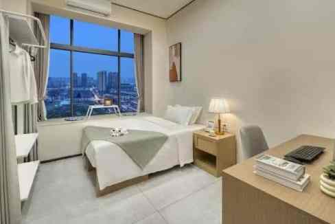 Bright hotel room with large window, bed, and workspace at Changsha Liatang Road Aparthotel.