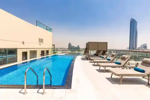 Rooftop pool at Dubai Jaddaf Waterfront Aparthotel offering stunning city skyline views. Perfect for.