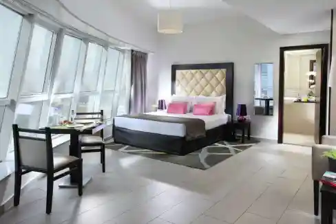 Spacious hotel-style bedroom with city views and contemporary decor in Dubai.