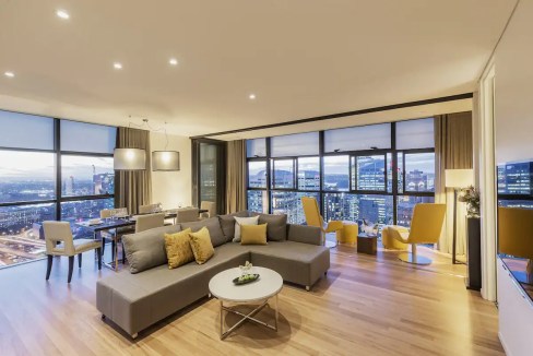 Spacious living area in Sydney Central Aparthotel with panoramic city views and contemporary furnish.