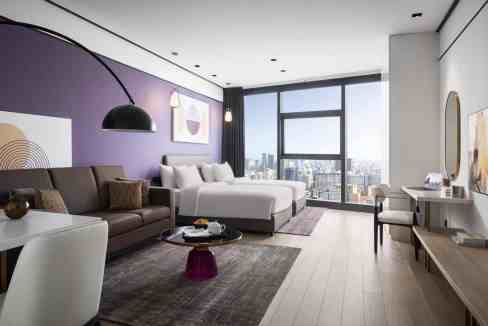 Luxurious hotel suite featuring a spacious layout, contemporary furnishings, and large windows overl.