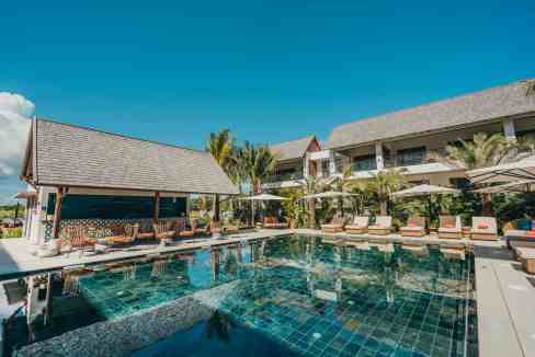Luxury pool at Mauritius Grand Baie Aparthotel with sun loungers and tropical surroundings.