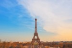 Eiffel Tower standing tall in Paris during sunset with a clear sky and cityscape background.