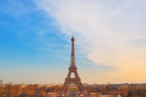 Eiffel Tower standing tall in Paris during sunset with a clear sky and cityscape background.