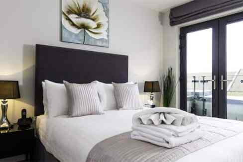 Spacious bedroom in West Ealing Uxbridge Rd Apartments featuring a large bed, contemporary decor, an.