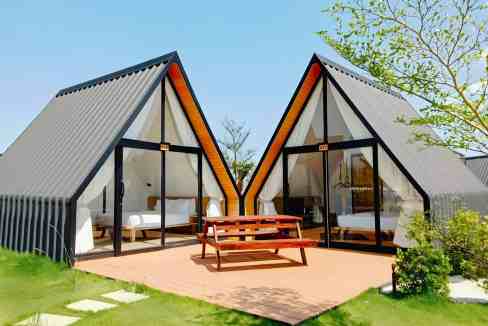 Modern beachfront bungalows with glass doors and wooden accents in Sihanoukville Beach Resort.
