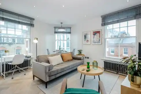 Bright and modern living room in Fitzrovia Newman Street Apartments with large windows and contempor.