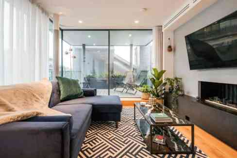 Spacious living room featuring contemporary furniture, large windows, and a cozy atmosphere.