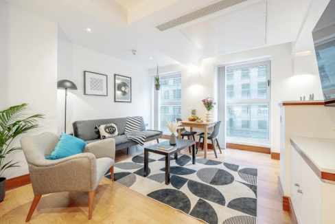 Bright and airy living room with contemporary furniture and large windows at Tower Hill Vine Apartme.