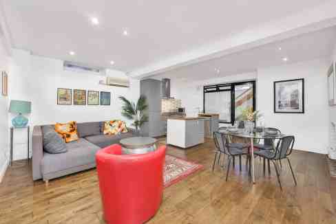 Spacious modern living room in Fullwood's Mews Warehouse with stylish furniture and open-plan kitche.