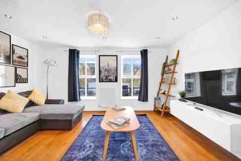 Bright living room with spacious seating and city views from large windows.
