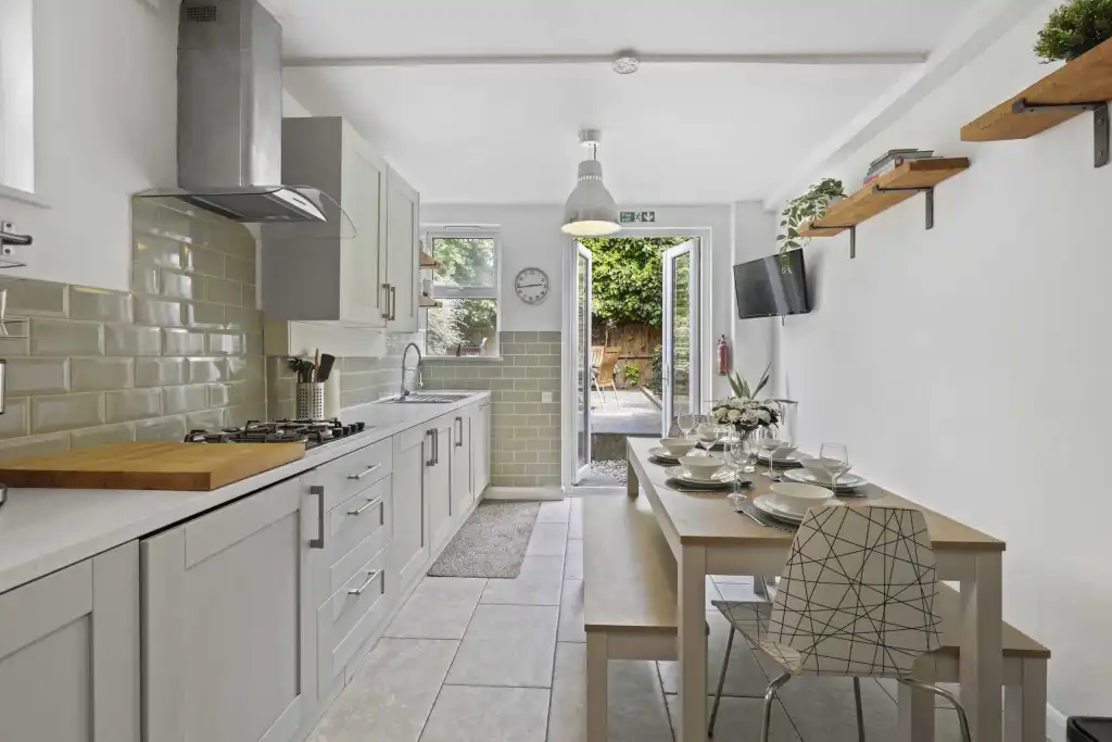 Bright kitchen with white cabinets and modern appliances in Greenwich Fingal Street House.