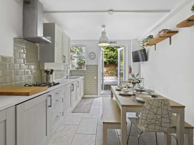 Bright kitchen with white cabinets and modern appliances in Greenwich Fingal Street House.