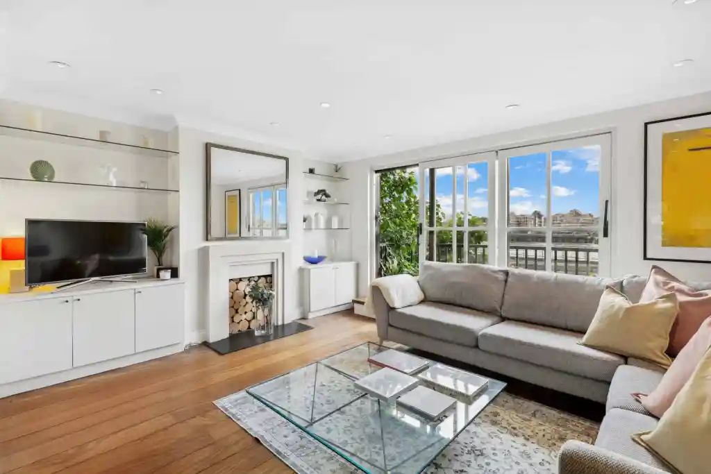 Bright living room with large windows overlooking the Thames. Modern decor with cozy sofa and stylis.