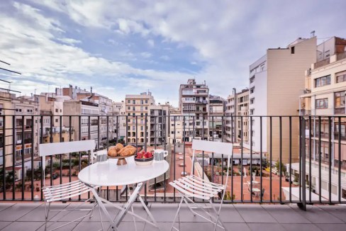 Balcony view of Carrer de Bailen apartments with cityscape and outdoor seating.