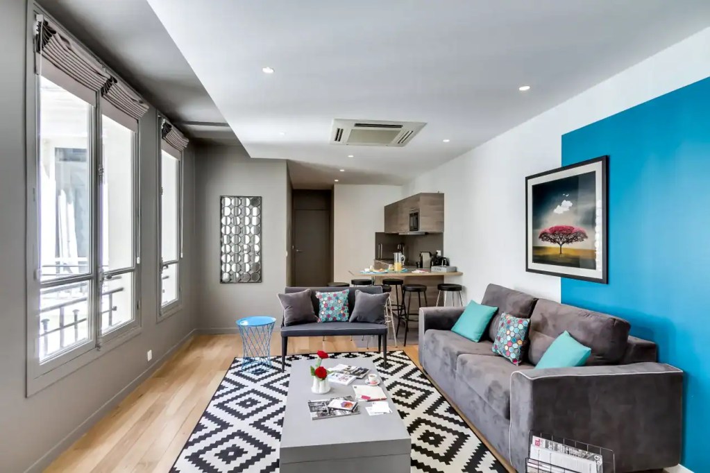 Stylish Champs-Elysees apartment living room with modern decor and large windows.