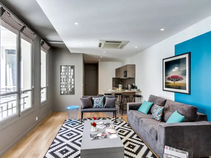 Stylish Champs-Elysees apartment living room with modern decor and large windows.