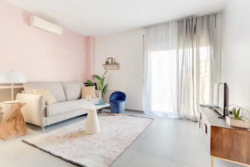 Modern living room in Plaza Joan Pelegri Apartments with bright natural light and contemporary decor.