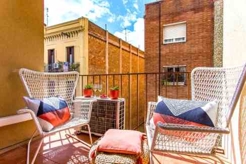 Balcony view at Plaza de Molina Apartments with outdoor seating and potted plants. Perfect for relax.