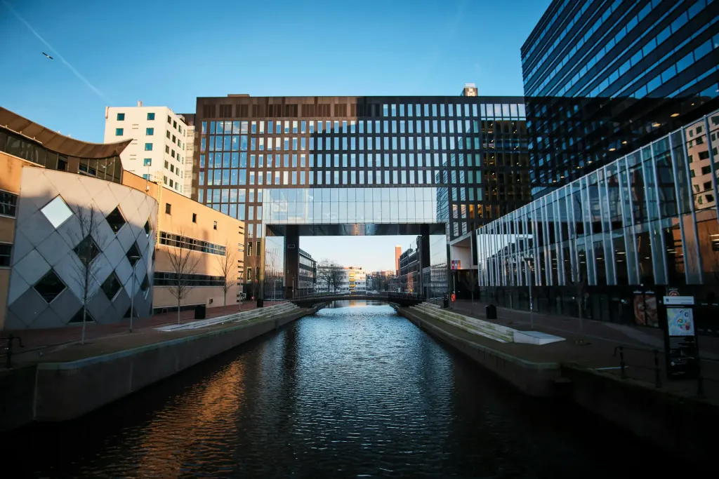 Amsterdam cityscape with canal and modern architecture.
