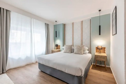 Stylish hotel bedroom at Paris Le Bastille Hotel with contemporary decor and soft lighting.