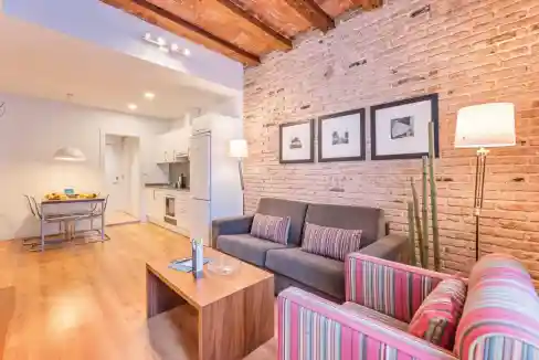 Cozy living room with exposed brick wall, stylish furniture, and contemporary decor in Travessera de.