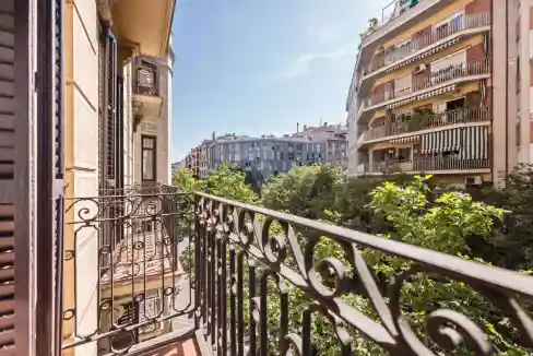 Balcony view of Carrer de Sepulveda apartments with lush greenery and surrounding buildings.