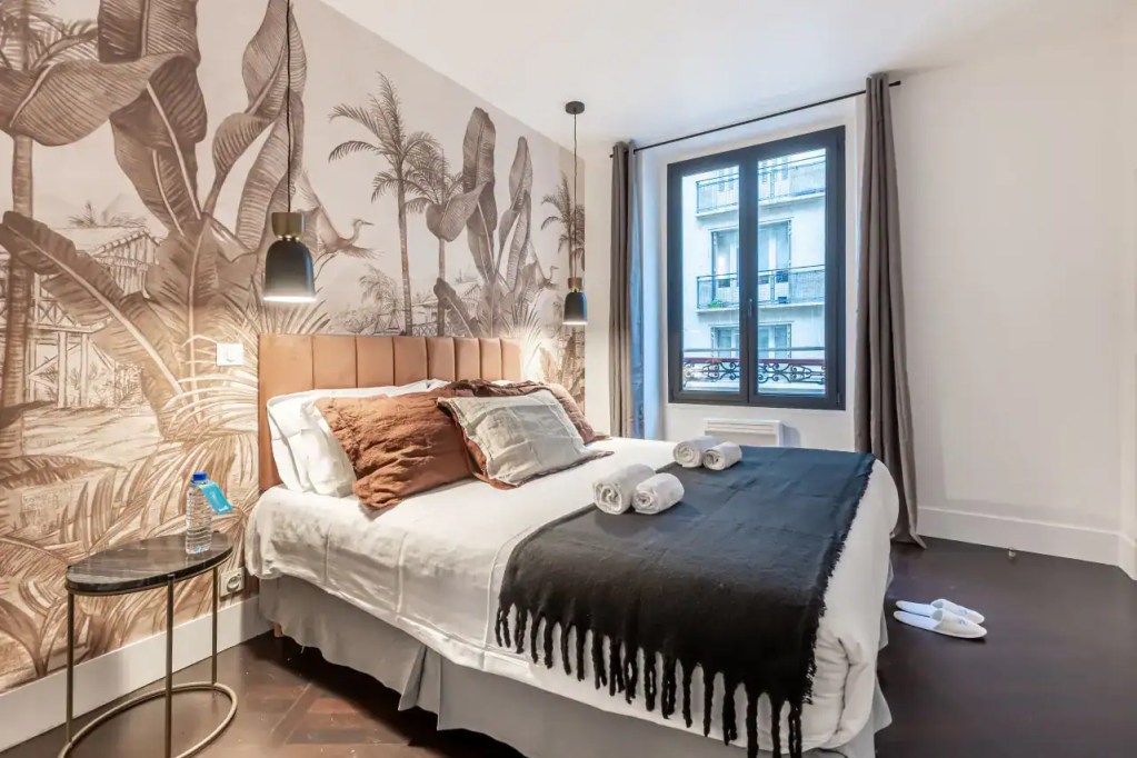 Stylish bedroom in Arc de Triomphe Apartments with contemporary decor and city views.