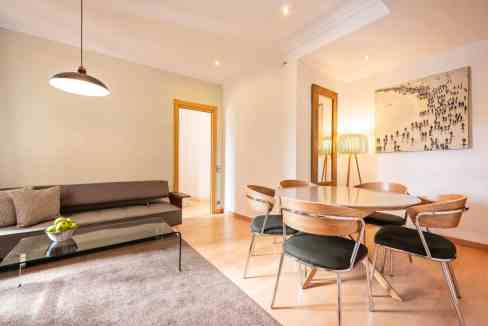 Contemporary living space featuring a dining table, artwork, and cozy seating arrangement.