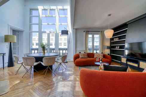 Spacious living area in Paris Wagram Apartments featuring large windows, contemporary furniture, and.
