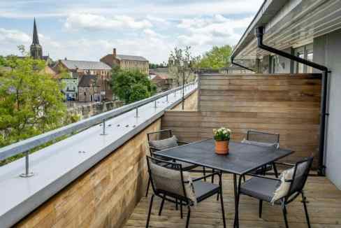 Modern balcony overlooking historic city walls and skyline.