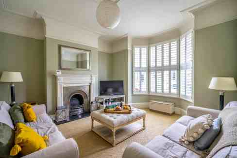 Bright living room with large bay windows and elegant decor.